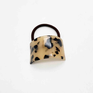 Detail of U-shaped acetate hair tie with tortoiseshell pattern and elastic band