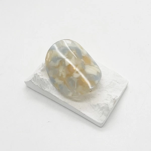 Detailed view of wide tortoiseshell acetate ring on a textured white stone base