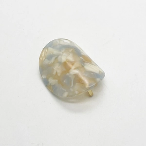 Detail of blue and yellow marble texture acetate ponytail hook with gold metal clasp