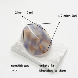 Oval acetate hair hook with purple marble pattern and size dimensions on white stand