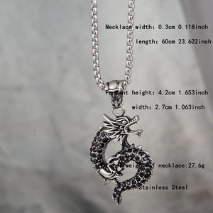 Macro shot of a silver dragon pendant featuring black crystals and round link chain