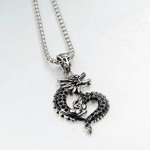 Detailed view of silver dragon pendant with black pave crystals on box chain necklace