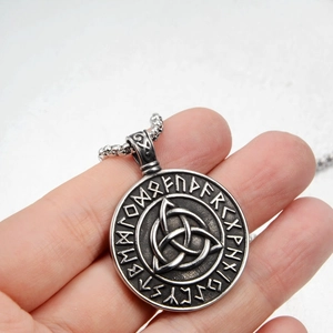 Macro detail of Nordic Celtic knot pendant with rune carvings and vintage silver finish