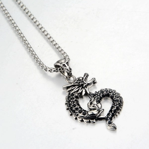 Close-up of a silver dragon pendant necklace with black rhinestones in a vintage style