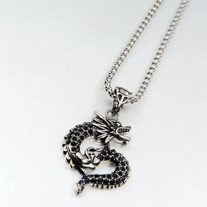 Detailed macro view of vintage dragon pendant necklace with black cubic zirconia stones