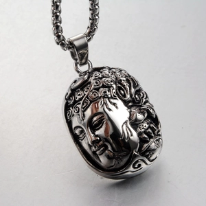 Close-up of vintage silver Buddha head pendant with intricate facial details on a metal chain