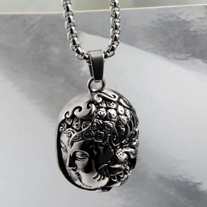 Macro detail of stainless steel half Buddha pendant with an intricate embossed texture