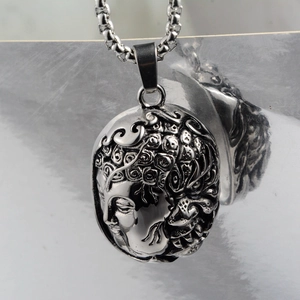 Macro view of vintage silver steel buddha pendant with detailed embossed carving