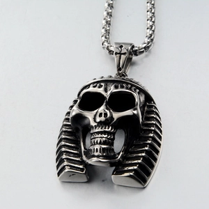 Macro view of stainless steel skull pharaoh pendant with cross detail on box chain