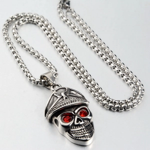 Detail view of gothic skull pendant with military officer hat and red gemstone eyes
