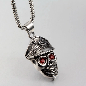 Macro view of punk skull necklace with army cap and red gem eyes in silver titanium steel