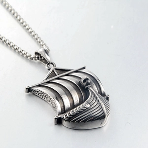 Macro view of vintage silver viking longship pendant with detailed dragon head on steel chain
