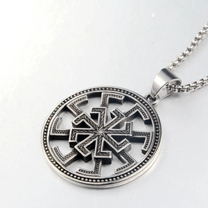 Macro detail of silver Slavic Kolovrat sun wheel pendant with stainless steel box chain