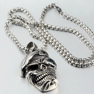 Détail d'un pendentif crâne punk vintage avec chapeau de pirate sur chaîne en acier inox