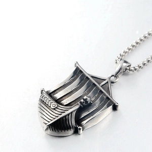 Macro detail of a vintage titanium steel Viking ship pendant with an antique silver finish