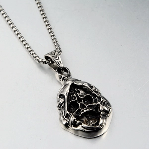 Close-up of gothic grim reaper skull pendant with vintage silver finish on steel chain
