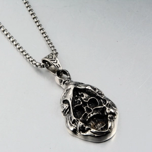 Macro view of Gothic grim reaper pendant in silver steel on a square box chain