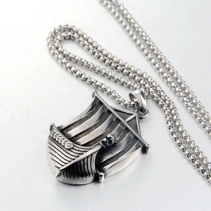 Detailed macro view of a vintage Viking longship pendant in oxidized stainless steel