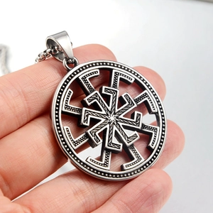 Macro shot of silver stainless steel Kolovrat sun wheel pendant with woven textures