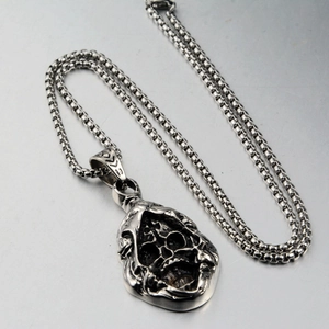 Close-up of gothic grim reaper skull pendant with vintage silver finish on metal chain
