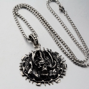 Macro shot of punk skull pendant with thorns and bones on stainless steel bead chain