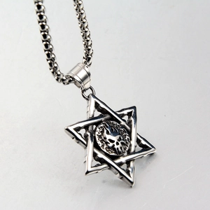 Macro shot of silver hexagram skull pendant with flame details on bead chain necklace