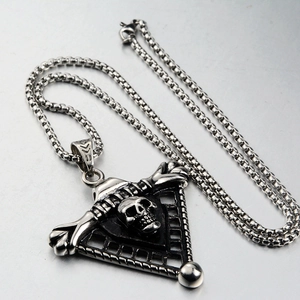 Macro detail of gothic triangle skull pendant on stainless steel chain with vintage finish