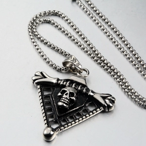 Macro shot of punk gothic skull pendant on triangular mesh with silver box chain link
