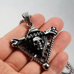 Macro shot of a gothic silver skull pendant on a tripod frame with vintage steel finish