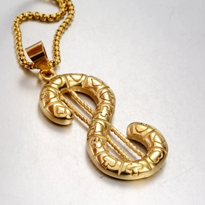Macro view of gold dollar sign pendant with embossed texture and round box chain
