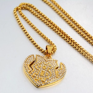 Détail du collier pendentif cœur signe dollar doré avec des zircons scintillants