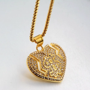 Gros plan du pendentif cœur doré avec signe dollar et cristaux brillants sur chaîne