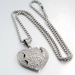 Vue détaillée du pendentif cœur brisé avec signe dollar et cristaux brillants