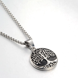 Detail of Tree of Life pendant in polished stainless steel with antique finish accents