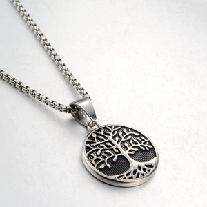 Macro shot of silver Tree of Life pendant with intricate hollow carving on a box chain