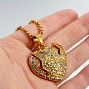 Détail du pendentif cœur brisé dollar avec cristaux brillants sur chaîne dorée