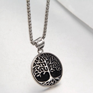 Detailed close-up of tree of life pendant in silver finish with vintage metal textures