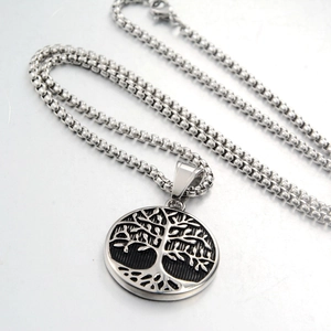 Close-up of a silver Tree of Life pendant with black details and square box chain