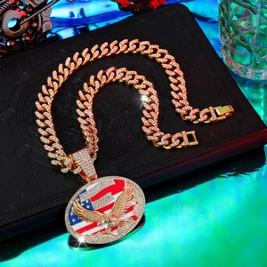 Dettaglio macro del ciondolo aquila con strass su catena cubana dorata stile hip-hop