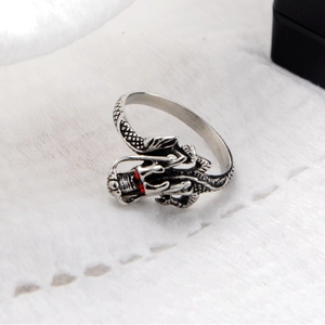 Anello drago vintage in argento con occhi in pietra rossa su sfondo di pelliccia bianca