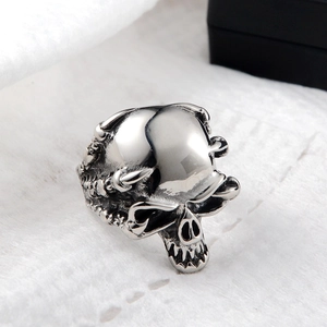 Macro view of a silver skull ring with gothic punk details on white plush fabric