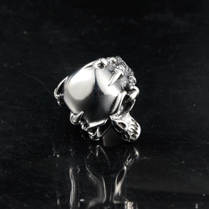 Macro detail of vintage skull ring with intricate bone carvings and polished silver finish