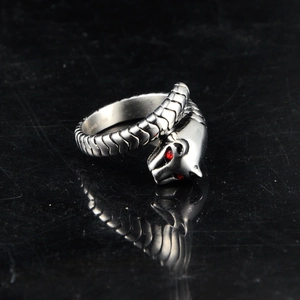 Macro shot of punk snake head ring with red crystal eyes and stainless steel stamp