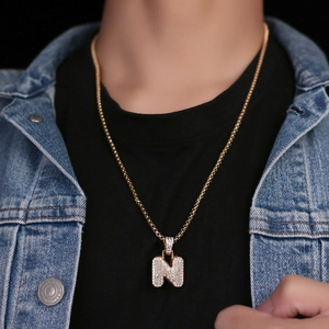 Dettaglio della collana con ciondolo lettera N in oro con zirconi lucidi e catena a scatola