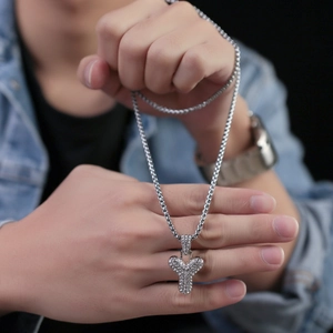 Dettaglio della collana hip hop argentata con lettera Y e cristalli lucidi per donne