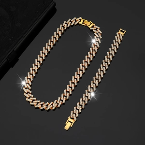 Close-up of golden iced-out Cuban link chain and bracelet set with sparkling crystals