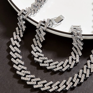 Detail of silver-colored iced-out Cuban link chain and bracelet set with sparkling rhinestones