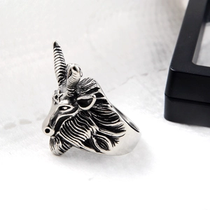 Detailed macro shot of vintage silver goat head ring with engraved pentagram and ram horns