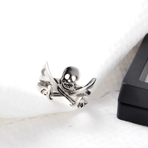 Macro shot of silver pirate skull and dual swords design on a stainless steel ring