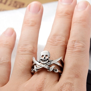 Macro shot of silver hip-hop skull ring with crossed swords and punk hollow frame design